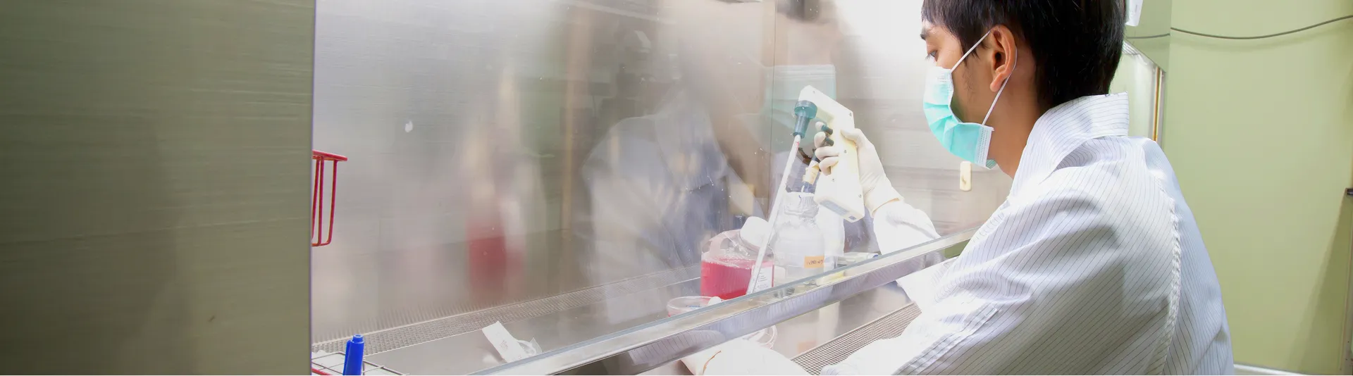 白衣を着てマスクをした男性が研究をしている様子