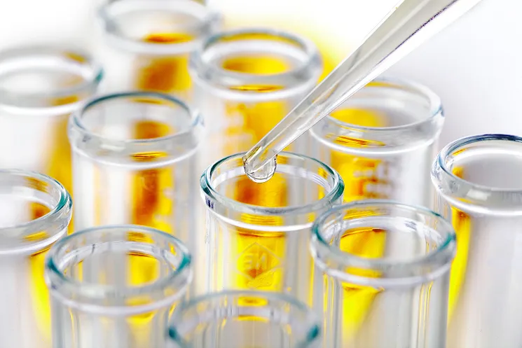 複数並んだ試験管に液体を移しているイメージ。
